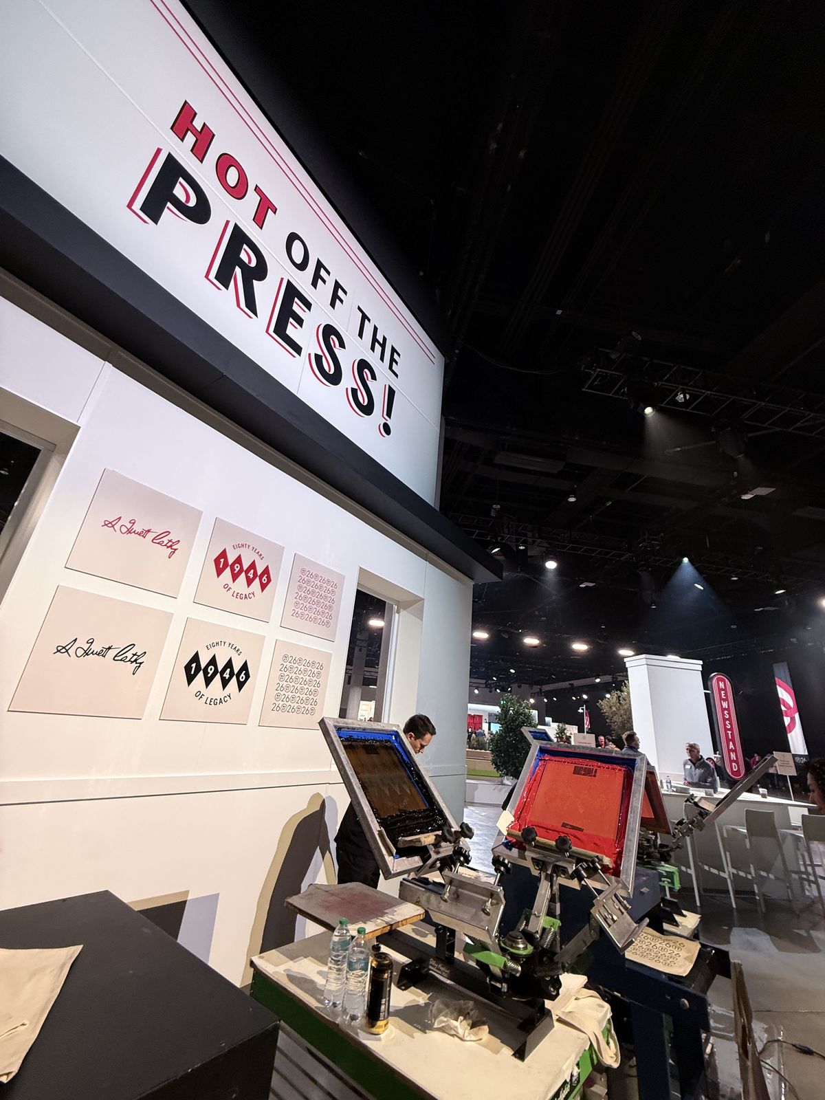 Custom-built press station backdrop with framed prints above the equipment